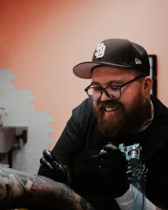 Tattoo artist Adam Sayre working on custom tattoo at Good Company Tattoo in San Diego