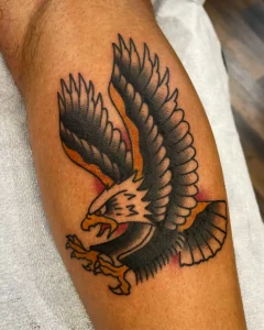 Traditional eagle tattoo with bold black and orange shading on forearm by San Diego tattoo artist